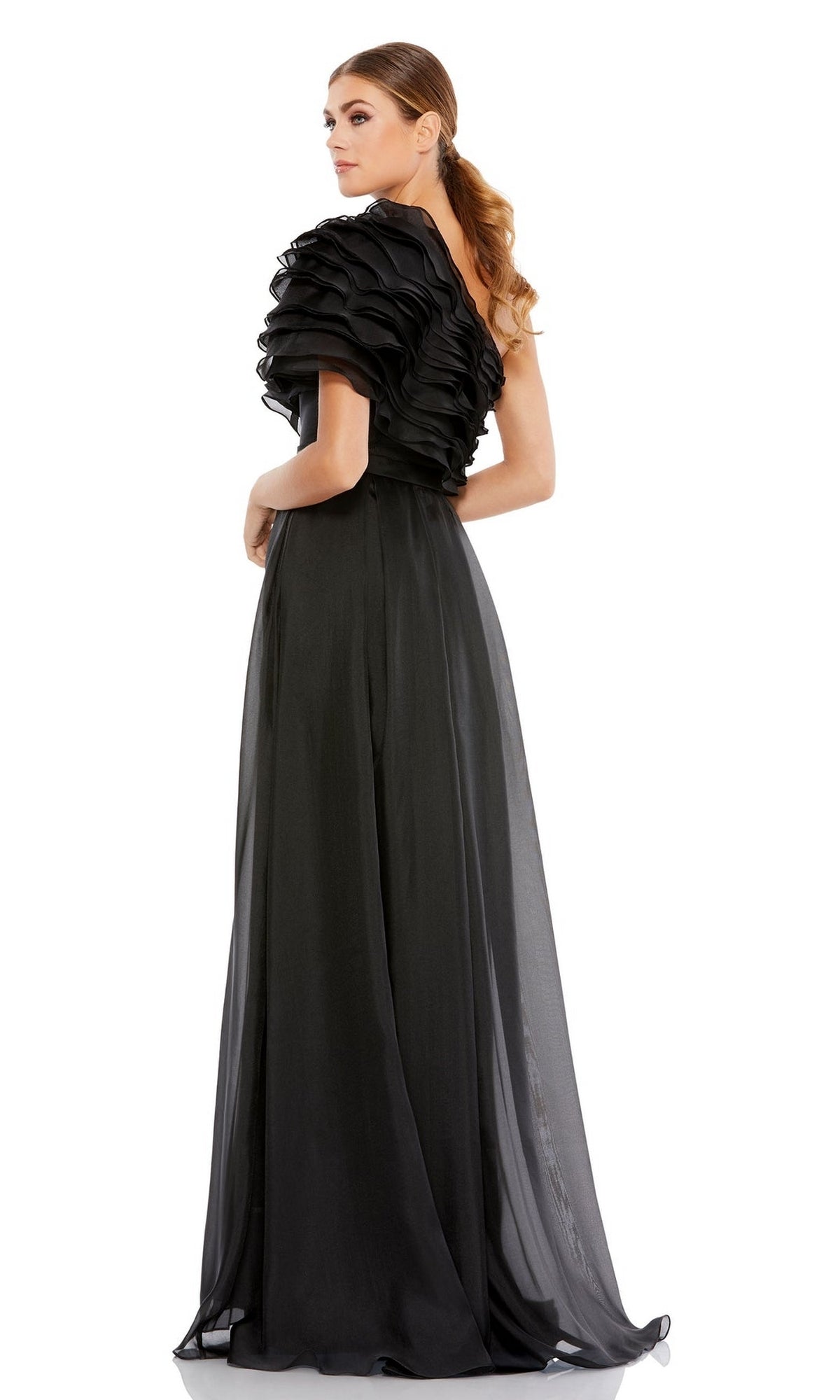 A woman stands looking over her shoulder in the Mac Duggal 26527 One-Shoulder Black Formal Dress, featuring ruffled detailing on the shoulder and bodice.
